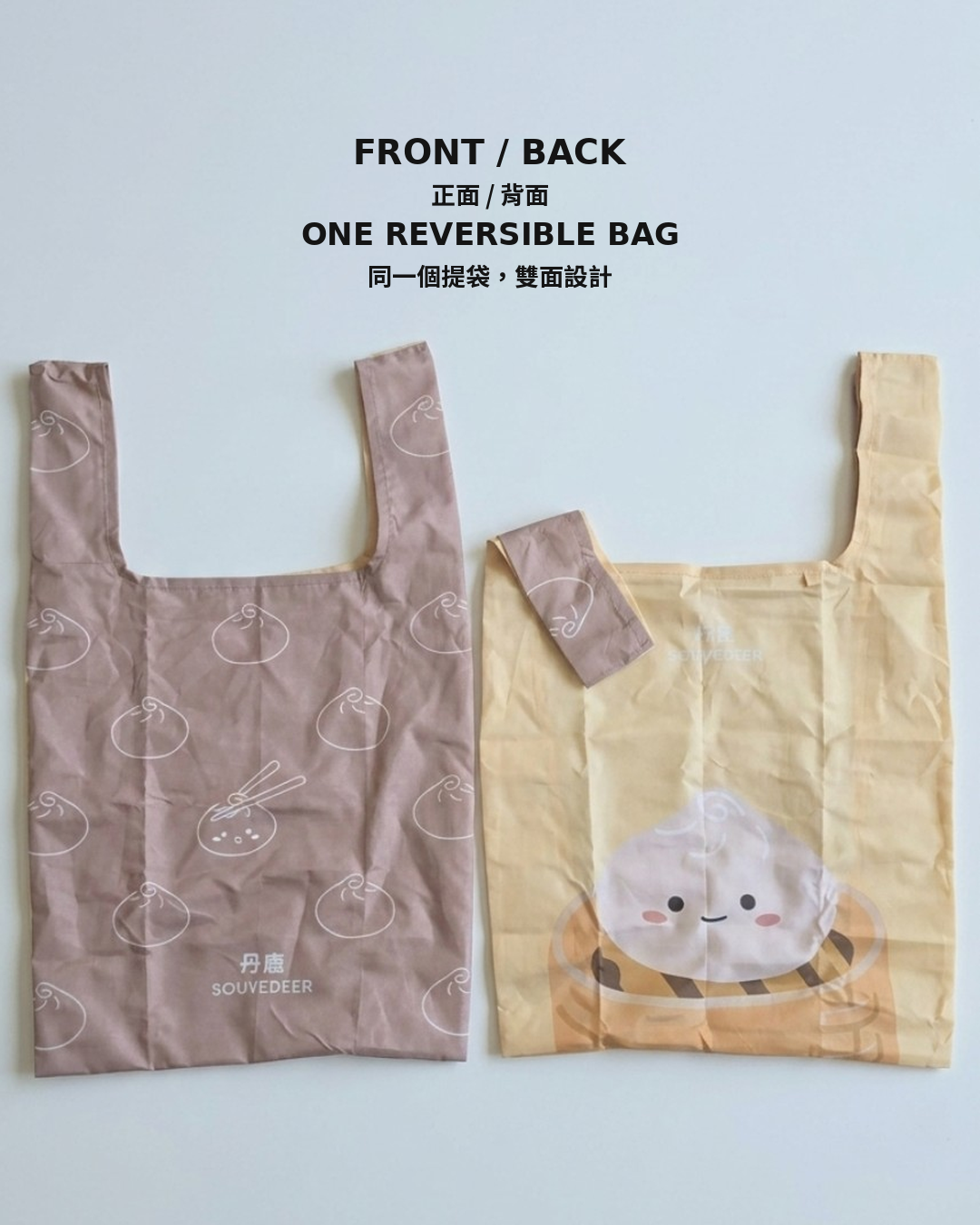 Two reusable tote bags shown side by side on a light gray background with text reading 'FRONT / BACK ONE REVERSIBLE BAG'. The left bag is dusty pink with white dumpling line drawings and small 'SOUVEDEER' text near the bottom.